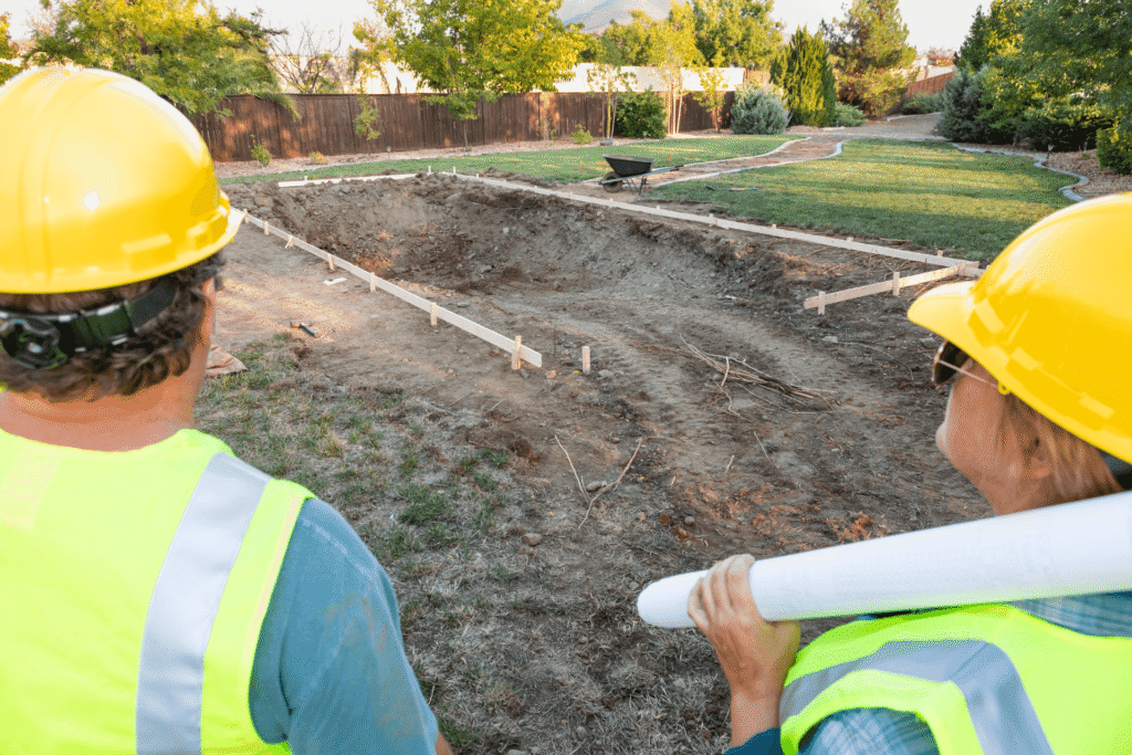 Des experts en terrassement de piscines en Moselle analysent le respect les paramètres essentiels sur un chantier en cours à Metz
